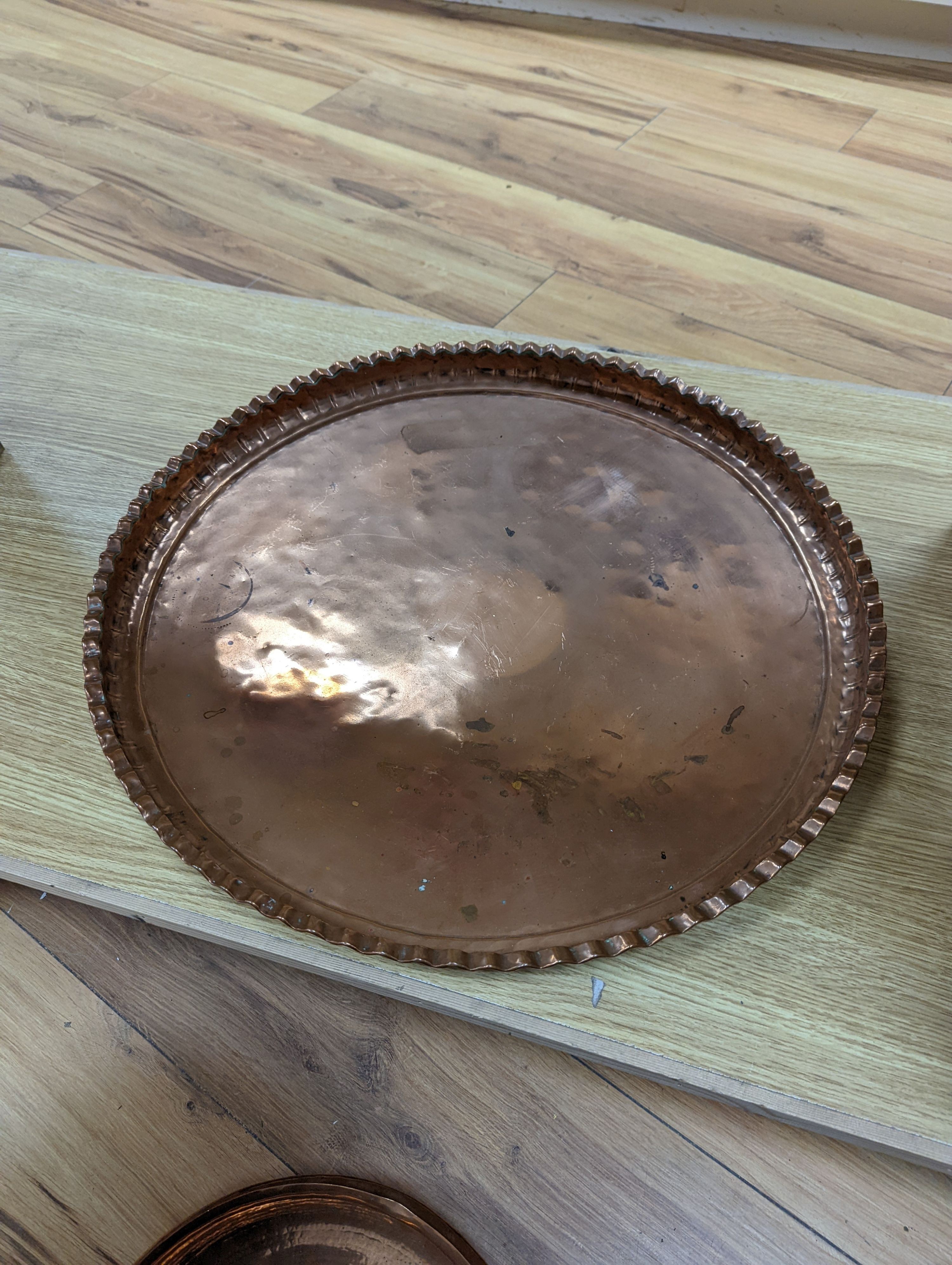 A copper coal scuttle and an Arts and Crafts hammered copper bowl and a similar tray